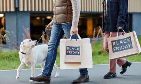 Adult Couple Holding Shopping Bags With Black Friday While Walking Outdoors