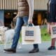 Adult Couple Holding Shopping Bags With Black Friday While Walking Outdoors